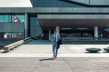 man walking holding a coat